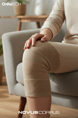 Evde otururken Novus Corpus OrthoTech bej örgü dizlik kullanan kişi
