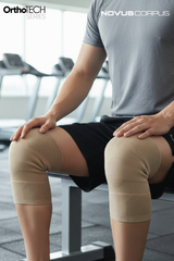 Spor salonunda Novus Corpus OrthoTech bej örgü dizlik çifti kullanan sporcu
